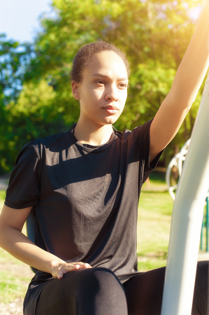 Active young woman exercising on elliptical trainer machineの写真素材
