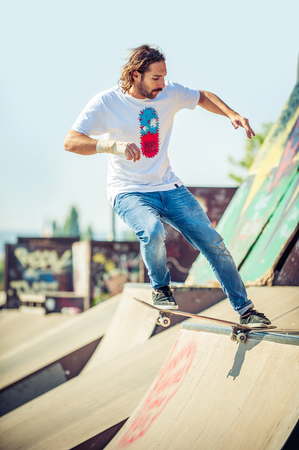 Action shot of a skateboarder skating at the skate park with concrete rampsの写真素材