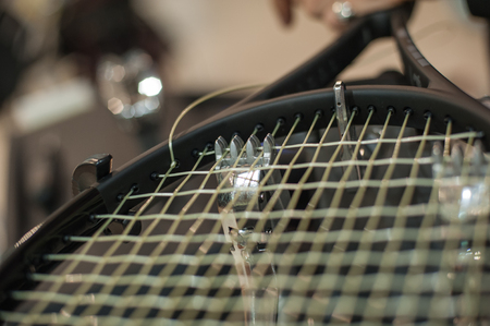 Racket stringing. Detail of tennis racket in the stringing machineの写真素材