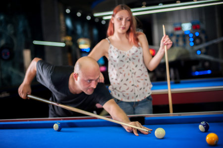 Beautiful couple flirting while playing snooker