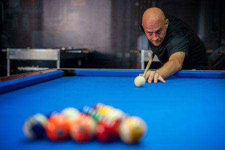 Young man playing billiard in a pool hall
