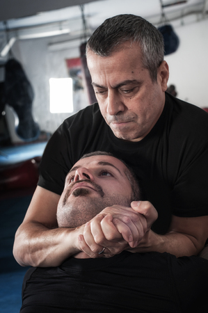 Kapap instructor demonstrates choke techniques with his studentの写真素材