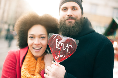 Beautiful young lovers holding a big red heart in sunny day. Valentines Dayの写真素材