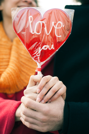 Beautiful young lovers holding a big red heart in sunny day. Valentines Dayの写真素材