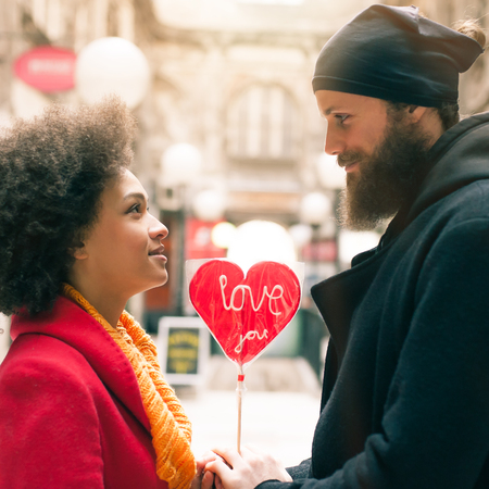 Beautiful young lovers holding a big red heart in sunny day. Valentines Dayの写真素材