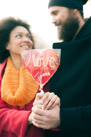 Beautiful young lovers holding a big red heart in sunny day. Valentines Dayの写真素材