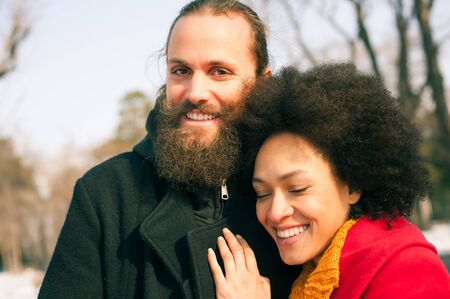 Portrait of romantic multiethnic couple in love hugging on the street. Falling in loveの写真素材
