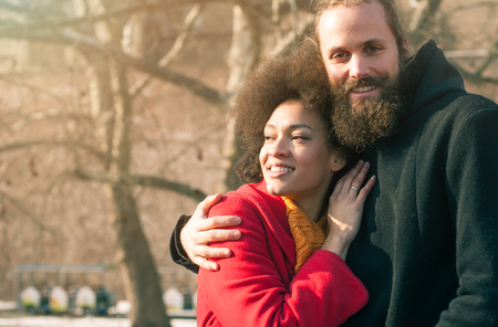 Portrait of romantic multiethnic couple in love hugging on the street. Falling in loveの写真素材