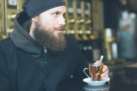 Portrait of handsome young man enjoying tea in a restaurantの写真素材