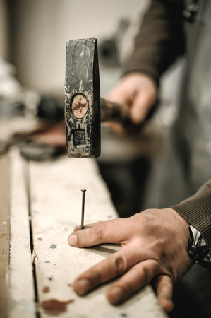 Carpenter using hammer for his job in carpentry workshop. Close upの写真素材