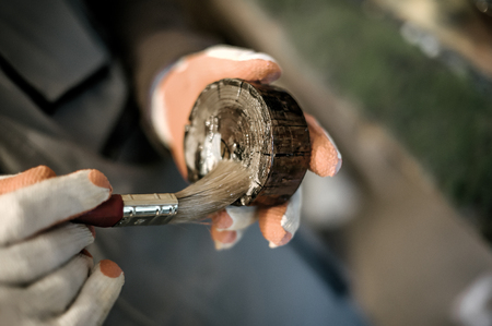 Carpenter using wood finish paint for his job in carpentry workshop. Close upの写真素材