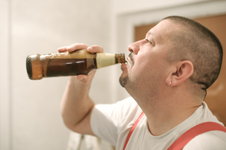 Portrait of construction mason worker drinking beer during working breakの写真素材