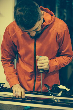 Ski repair shop worker adjust the bindings and equipment. Winter workshop serviceの写真素材