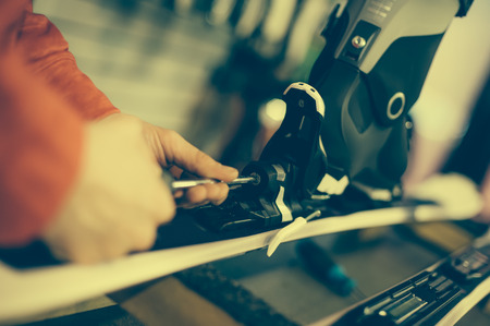 Ski repair shop worker adjust the bindings and equipment. Winter workshop serviceの写真素材