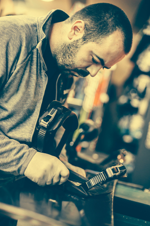 Snowboard repair shop worker adjust the bindings and equipment. Winter workshop serviceの写真素材