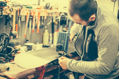 Wax ski and snowboard. Workshop worker doing waxing and reapairsの写真素材