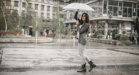 Portrait of happy smiling woman under umbrella in rainの写真素材