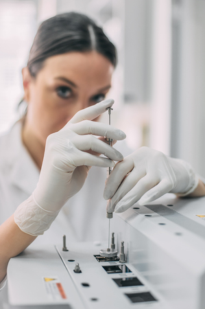 Portrait of female researcher doing research in a chemistry lab. Gas chromatograph analyzerの写真素材