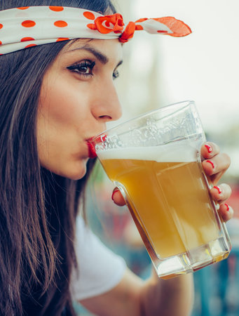 Portrait of beautiful young woman drinking beer and enjoying summer dayの写真素材