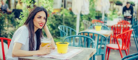 Portrait of beautiful young woman drinking beer and enjoying summer dayの写真素材