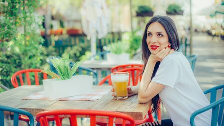 Portrait of beautiful young woman drinking beer and enjoying summer dayの写真素材