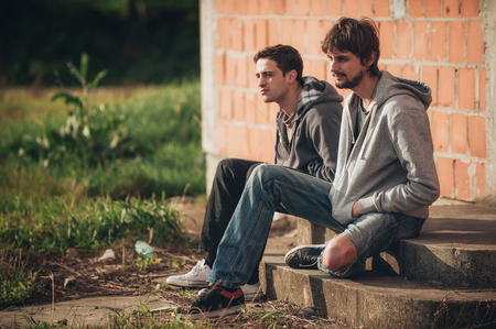 Two depressed and sad young buddies friends thinking together about their problemsの写真素材