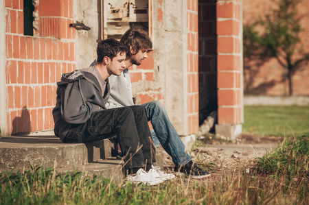 Two depressed and sad young buddies friends thinking together about their problemsの写真素材