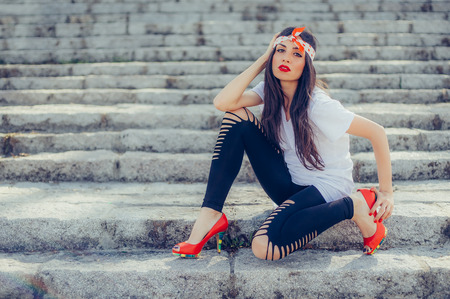 Beautiful and pretty fashion style long hair woman posing on the stairsの写真素材