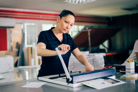 Young woman working in printing factory. Printing Press
