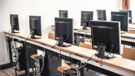 Photo of row computers in classroom or other educational institution. Close upの写真素材