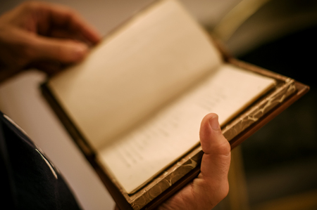 Curious man reading old book in his library. Close upの写真素材