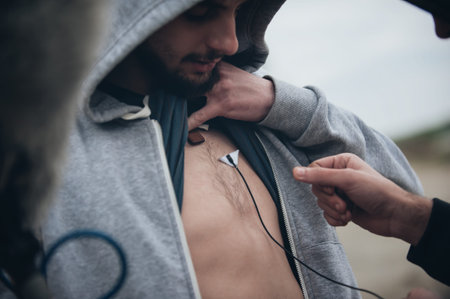 Behind the scene. Sound technician puts the lavalier microphone under actor shirts. Lav micの写真素材
