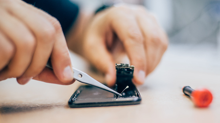 Technician repair faulty mobile phone in electronic smartphone technology service. Cellphone technology device maintenance engineerの写真素材