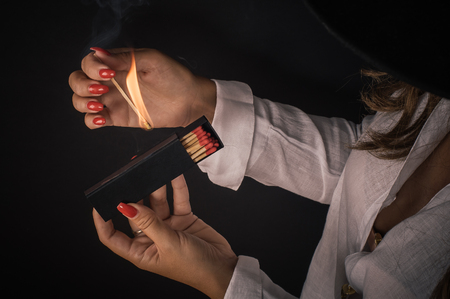 Womens hands ignite big matches for a tompus cigare or a fireplace. Studio shootの写真素材