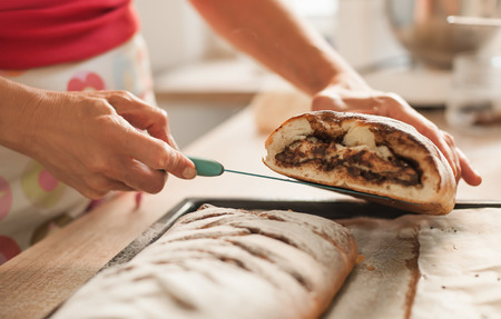 Woman cutting chocolate cake with sugar decoration with kitchen knife. Close upの写真素材