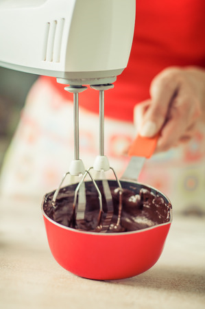 Woman hands mixing melted chocolate in the kitchen. Close upの写真素材