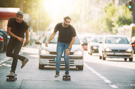 Two professional skateboarders riding skateboard slope on the capital city streetsの写真素材