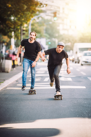 Two professional skateboarders riding skateboard slope on the capital city streetsの写真素材