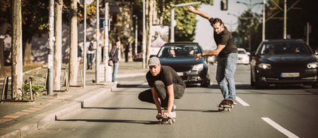 Two professional skateboarders riding skateboard slope on the capital city streetsの写真素材