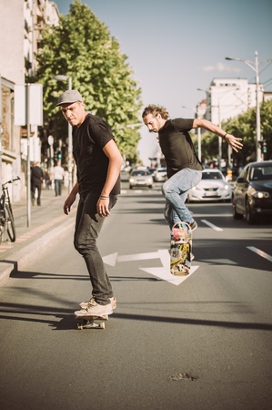 Two professional skateboarders riding skateboard slope on the capital city streetsの写真素材