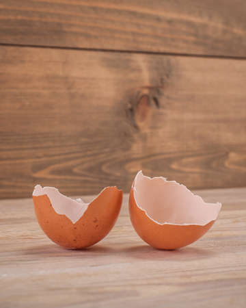 Close up of broken eggshell on rustic wooden tableの写真素材