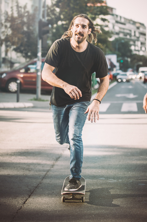 Pro skate rider ride skateboard in front of the car on the city road street through traffic jamsの写真素材