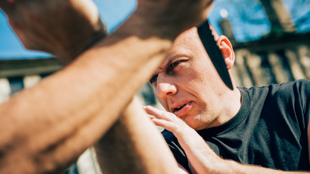 Kapap instructor demonstrates martial arts self defense knife attack disarming technique against...