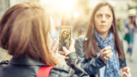 Two girl friends happy watching internet social media in smartphone. Close up