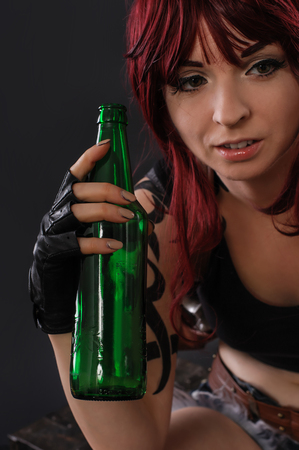 Photo of sexy young woman drinking beer from bottle. Studio shootの写真素材
