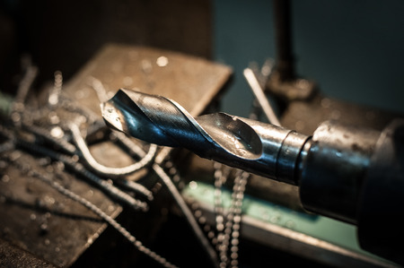 Large and powerful automatic heavy industrial drill bit cutting the metal block at the factoryの写真素材
