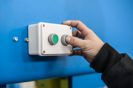 Industrial machinery mechanics and factory worker adjusts industry machine and checks if everything works properlyの写真素材