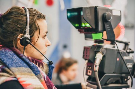 Behind the scene. Female cameraman shooting the film scene with camera in film studioの写真素材