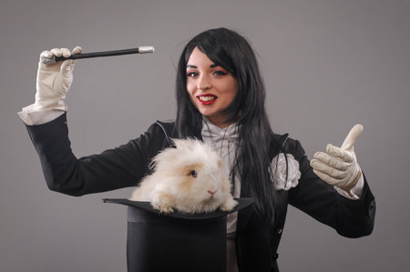 Beautiful woman magician with rabbit in hat. Close upの写真素材