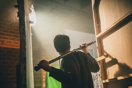 Behind the scene. Sound boom operator hold microphone fisher on the setの写真素材